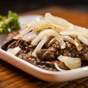 pedaços de fígado frito com cebola, folhas frescas de saladas